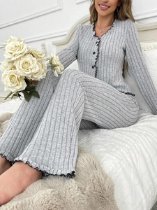 Detail of grey ribbed knit loungewear set featuring black lettuce trim and V-neck cardigan