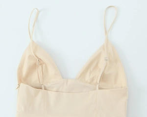 Detail view of beige poplin midi dress featuring slim adjustable straps and a V-neckline