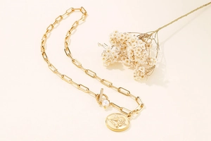 Gold paperclip link necklace with angel coin pendant, T-bar clasp, and pearl detail
