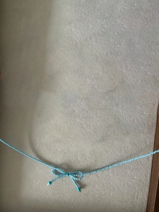 Détail macro d'un collier en perles bleues avec un nœud papillon fait main pour femmes