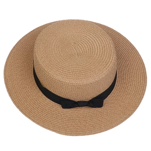 Top view of a wide brim straw boater hat with a black ribbon bow on white background