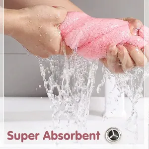 Pink microfiber hair drying towel with ultra-absorbent fabric being squeezed dry