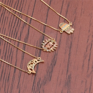Detailed view of gold MAMA and MOM pendants with colorful zircon on wood background