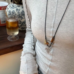 Bohemian grape pendant necklace with multilayered beads on a grey long sleeve top