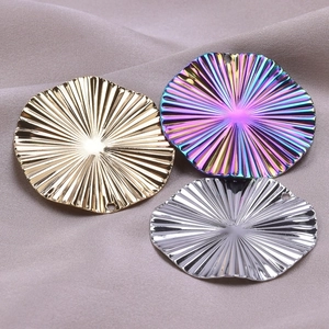 Macro shot of sunburst textured round metal pendants in gold, silver, and rainbow finishes