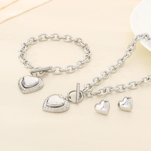 Detailed view of silver stainless steel jewelry set including heart necklace and bracelet