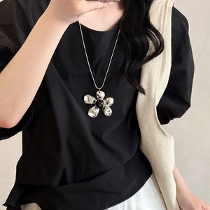 Metallic resin flower pendant necklace with silver chain on model, minimalist fashion style