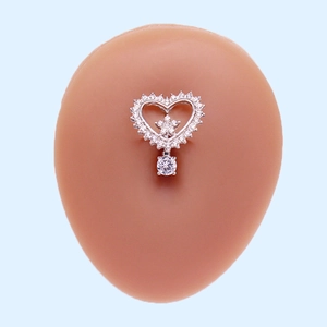 Macro detail of silver heart belly ring with star design and dangling round crystal