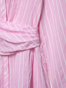 Detail of pink and white striped dress showing cross-wrap design and white button closure