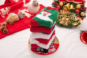 Close-up of thick coral fleece Christmas socks with festive patterns and soft texture