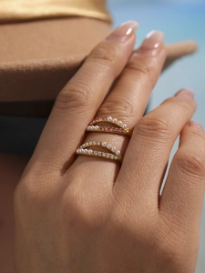 Detail of double-layer gold rings with pink and white zircons and pearls on hand