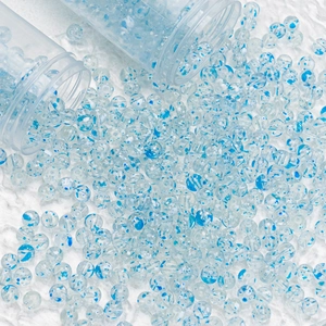 Close-up of 8mm blue spotted glass beads spilling from tubes for DIY jewelry making