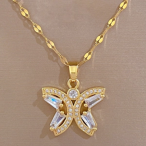 Detail of gold butterfly necklace featuring rectangular zircons and a textured flat chain