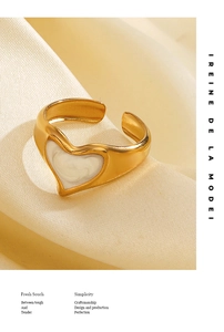 Detail of 18K gold-plated open heart ring on soft silk background with elegant textures