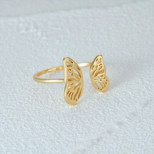 Detailed close-up of a gold-plated butterfly wing ring with an adjustable open band design