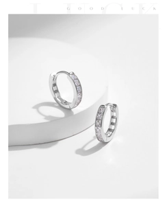 Macro shot of silver S925 U-shape earrings with clear cubic zirconia pavé setting