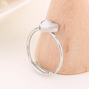 Detailed macro view of the minimalist stainless steel heart ring on a wooden cone stand