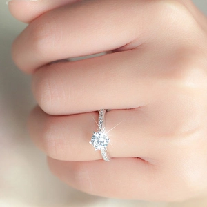 Classic six-prong solitaire ring with a round diamond and sparkling side stones