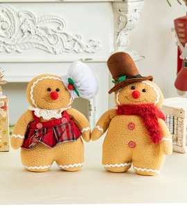 Close-up of plush gingerbread man dolls with red plaid details on a white fireplace