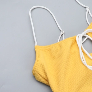 Détail du haut jaune en maille gaufrée montrant la texture du tissu et les fines bretelles
