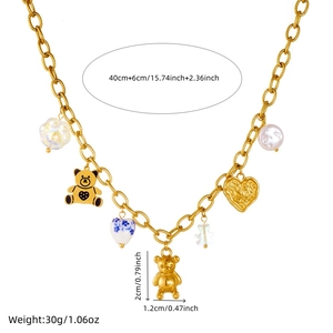 Gold plated necklace with 3D bear, heart and floral charms on a white background