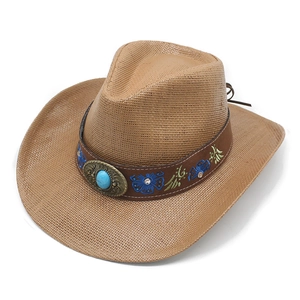 Detail of western straw hat with blue floral embroidery and turquoise centerpiece
