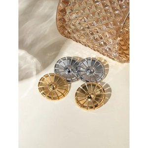 Detail von gänseblümchenförmigen Ohrringen in Gold und Silber auf bernsteinfarbenem Glas