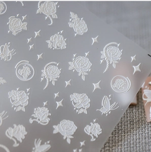 Vue détaillée de stickers 3D gaufrés pour ongles avec roses blanches et papillons