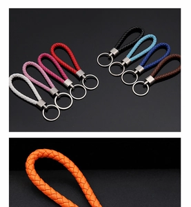 Dettaglio di vari portachiavi in pelle intrecciata colorata con anelli metallici inclusi