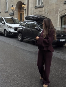Vue de rue d'un ensemble en maille bordeaux avec haut surdimensionné et pantalon large