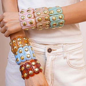 Acrylic geometric oval bangles with gold stud accents in assorted marbled colors