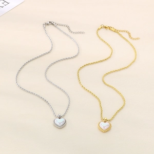 Gold and silver twist chain necklaces with iridescent heart pendants on soft fabric
