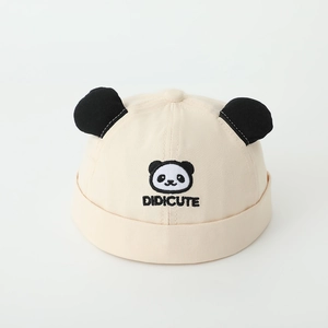 Detail of cute panda embroidery and soft cotton fabric on a beige infant brimless cap