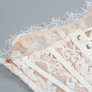 Detailed view of invisible side zipper and metallic eyelets with delicate eyelash lace trim