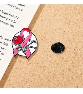 Detail der Emaille-Anstecknadel mit rosa Schleife, Rose und Faith of Love Schriftzug