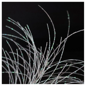 Close-up of white decorative branches with iridescent green glitter for festive tree decor