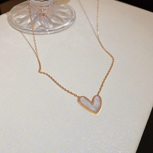 Macro shot of rose gold heart necklace with white mother of pearl inlay and fine chain
