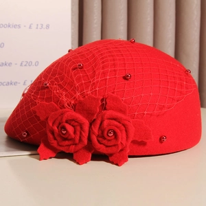 Close-up of red wool beret featuring elegant mesh veil and large handmade flower detail