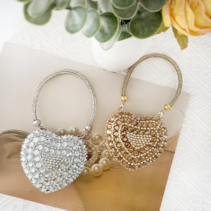 Detail of silver and gold heart-shaped mini bags with sparkling crystals on a table