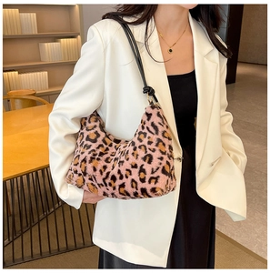 Dettaglio della borsa in peluche leopardata rosa con tracolla su una giacca bianca