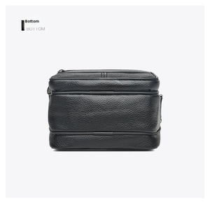 Close-up of the bottom of a black pebble leather crossbody bag with durable fine stitching