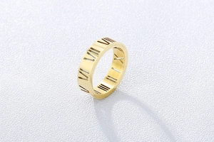 Macro detail of gold-plated titanium steel ring with hollow Roman numeral cutouts