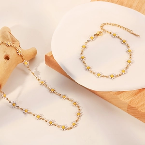 Primer plano detallado del conjunto de collar y pulsera de margaritas en oro de 18 quilates