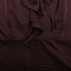 Détail d'une robe en satin marron foncé avec volants au col en V et cordons à nouer