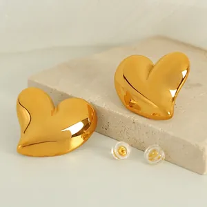 Boucles d'oreilles cœurs dorés en acier titane avec finition miroir sur socle