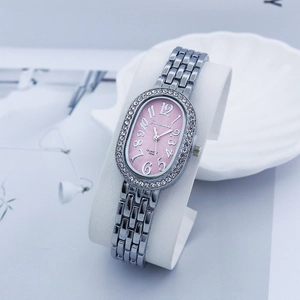 Macro detail of oval pink dial with crystal bezel and silver link strap on watch