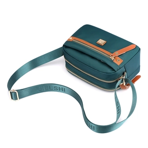 Waterproof nylon crossbody bag in dark teal with multiple compartments and gold hardware