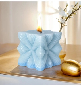 Modern light blue geometric pillar candle with artistic pleated design lit for home decor