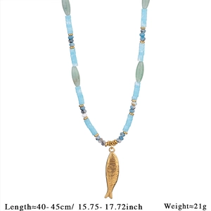Detailed macro view of the golden fish pendant on a blue and green natural stone necklace