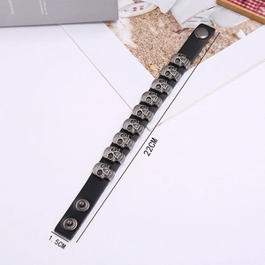 Detail view of punk leather bracelet with silver skull studs and adjustable snap button